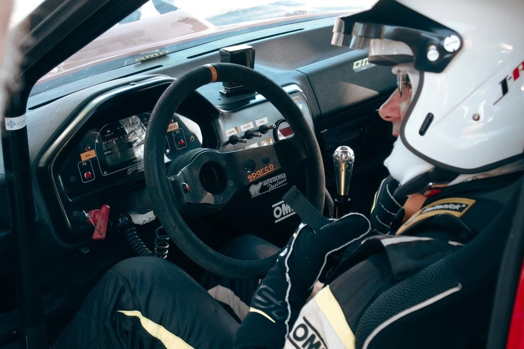 Interno dell'abitacolo di una vettura da corsa con volante Sparco e strumentazione